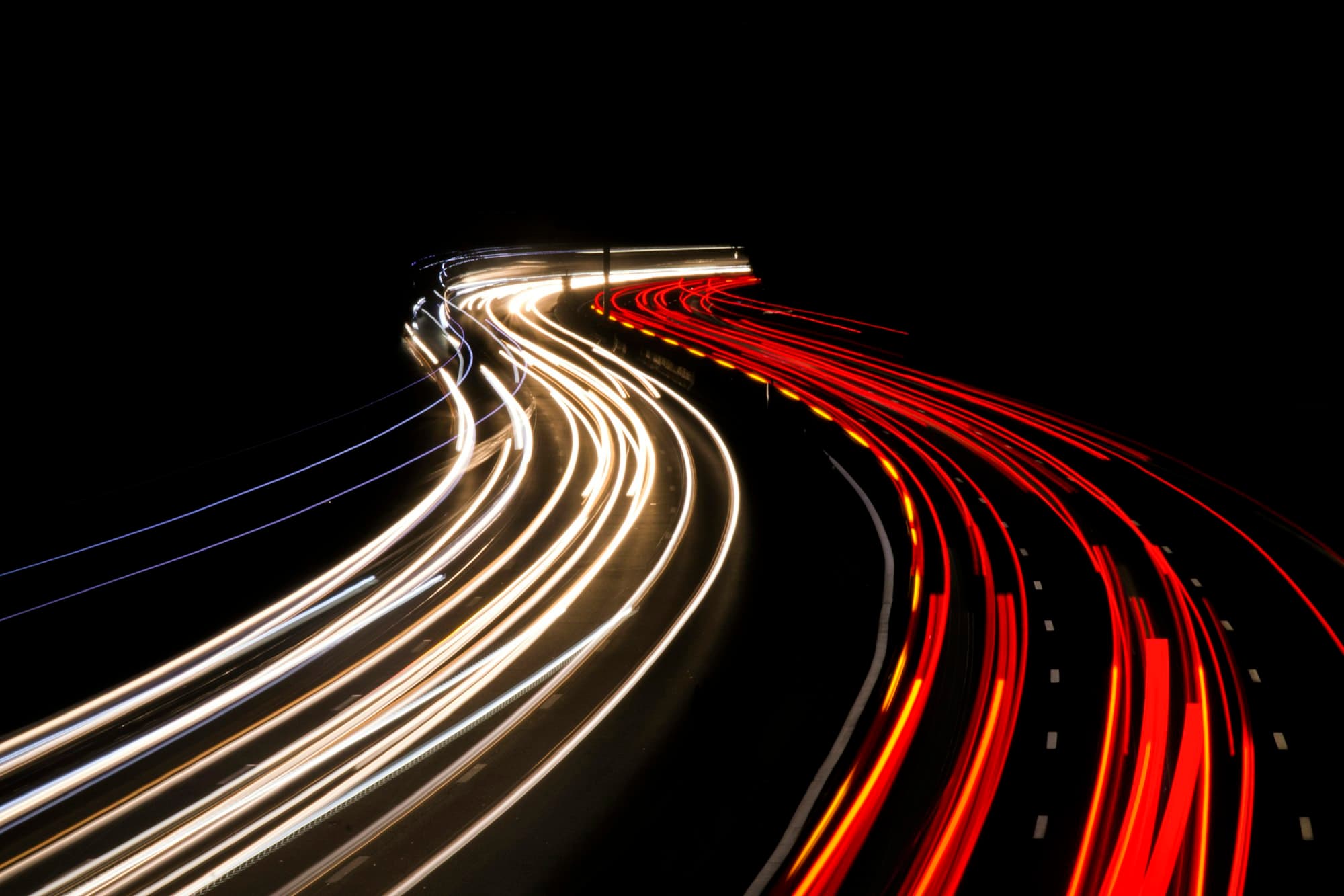 Nočná cesta so svetelnými stopami áut